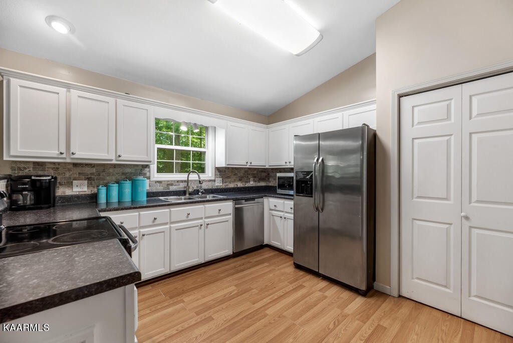 707 Jane Phillips Road Oneida, TN 37841 - Photo 3 of 25 a kitchen with stainless steel appliances granite countertop a refrigerator a sink dishwasher a stove with wooden cabinets and floor