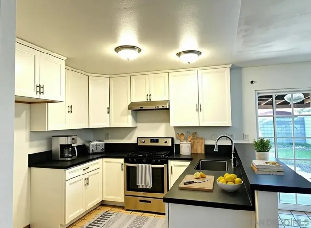 a kitchen with a stove a sink and cabinets