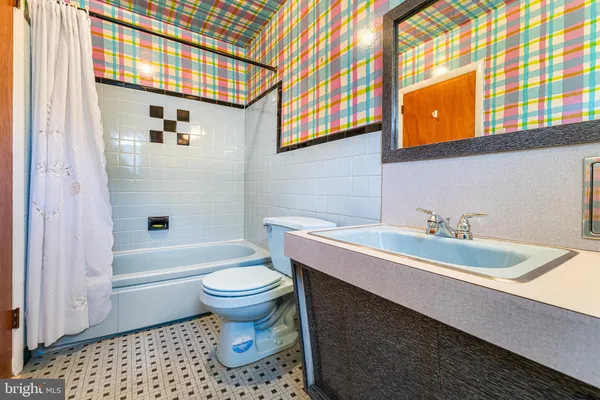 a bathroom with a sink a toilet and bathtub