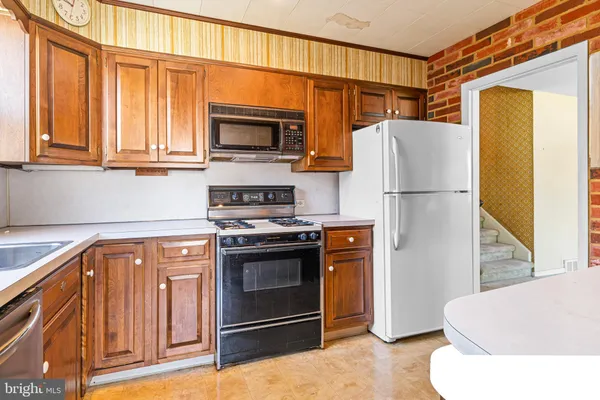 a kitchen with stainless steel appliances a refrigerator a stove a microwave a sink and cabinets