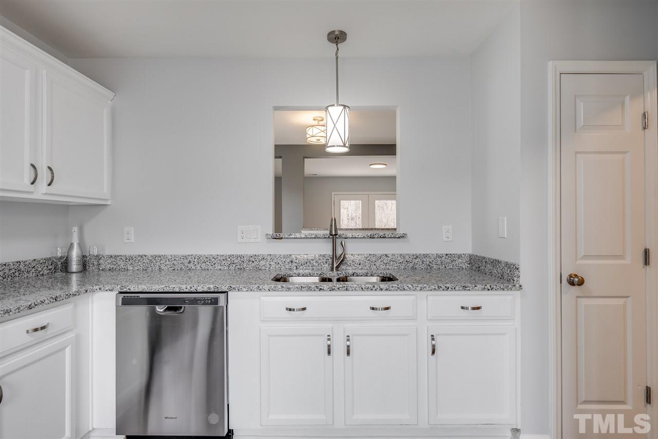 5408 Gunnette Drive Raleigh, NC 27610 - Photo 4 of 23 a kitchen with granite countertop a sink cabinets and window