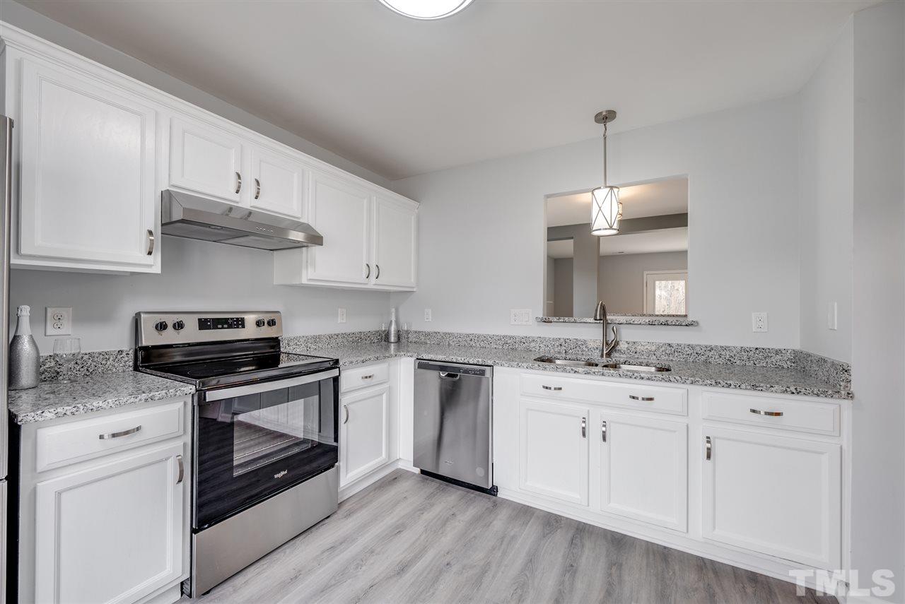 5408 Gunnette Drive Raleigh, NC 27610 - Photo 5 of 23 a kitchen with stainless steel appliances granite countertop a sink stove and white cabinets