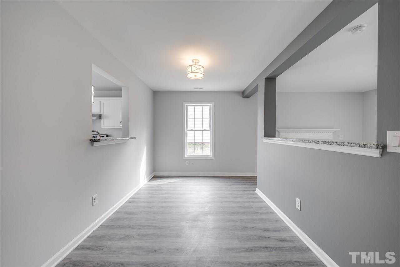 5408 Gunnette Drive Raleigh, NC 27610 - Photo 7 of 23 a view of a hallway with wooden floor and a window