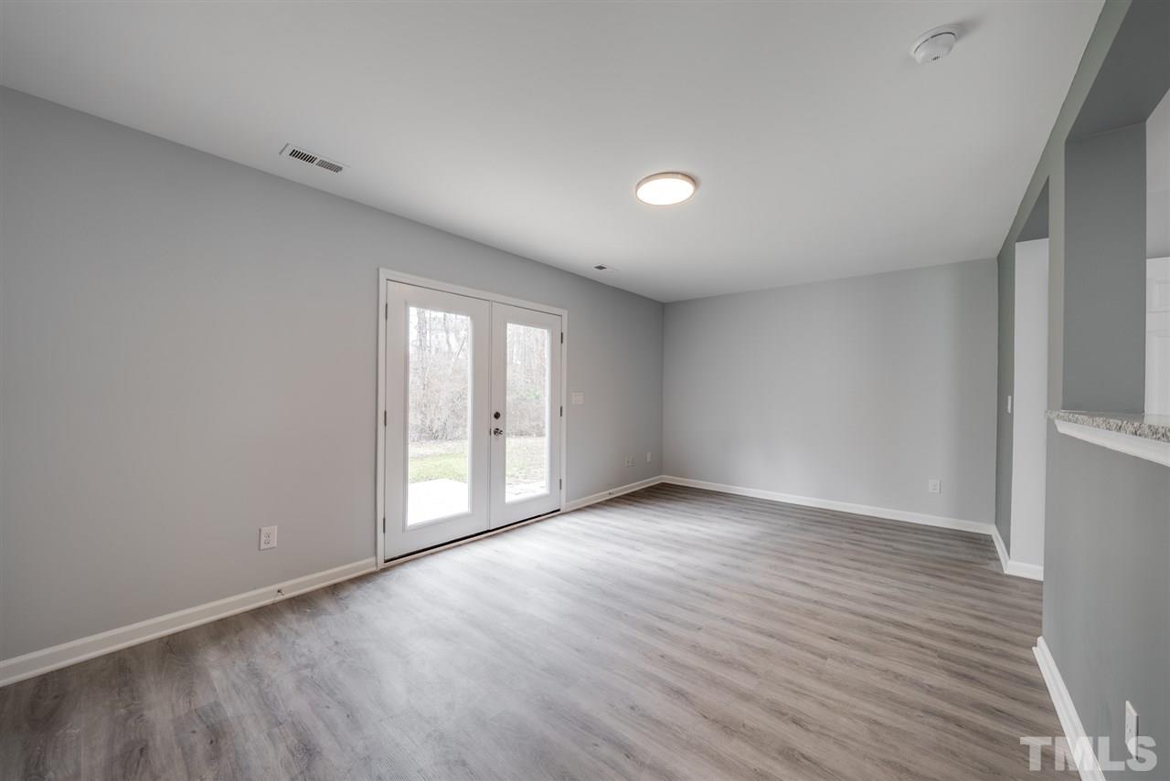 5408 Gunnette Drive Raleigh, NC 27610 - Photo 10 of 23 a view of an empty room with wooden floor and a window