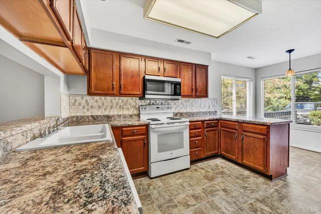 a kitchen with stainless steel appliances granite countertop a stove sink and microwave