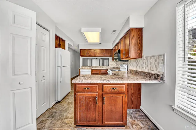 a kitchen with kitchen island granite countertop wooden cabinets and a sink