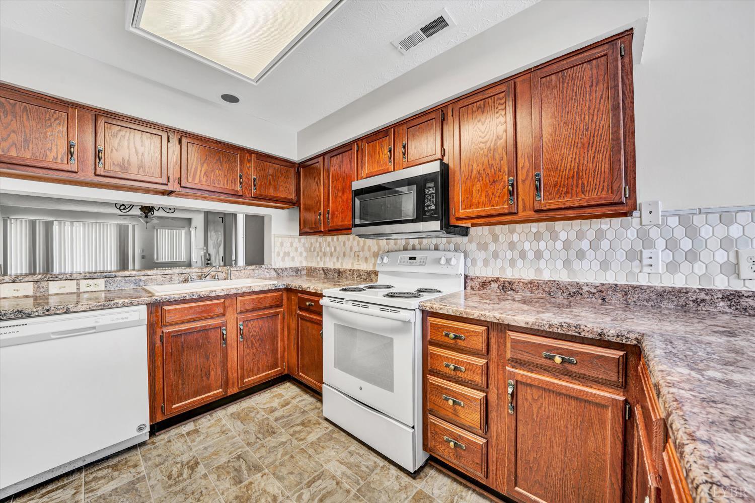 3114 Spinnaker Point Forest, VA 24551 - Photo 20 of 47 a kitchen with stainless steel appliances granite countertop wooden cabinets a stove top oven a sink and dishwasher