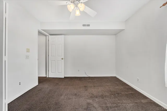 an empty room with a chandelier fan