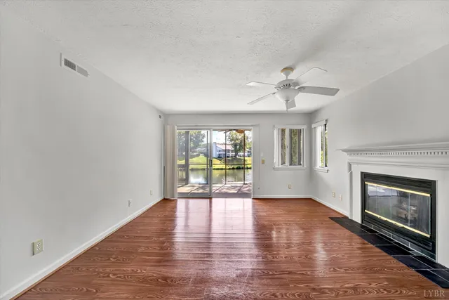 a view of an empty room with a window and fireplace