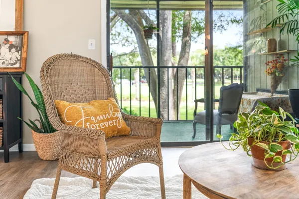 a living room with furniture and a dining table with wooden floor