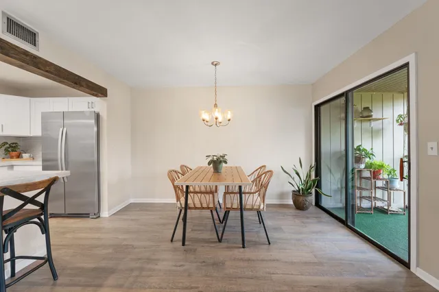 a dining room with furniture potted plants and wooden floor