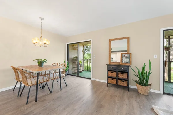 a kitchen with a stove a refrigerator a dining table and chairs with wooden floor