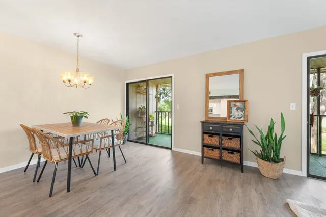 a kitchen with a stove a refrigerator a dining table and chairs with wooden floor