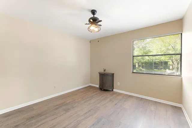 a view of hallway with a large window and wooden floor