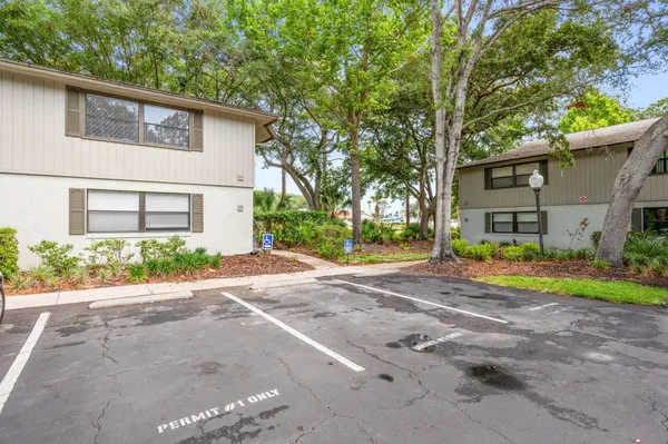 a view of a house with a yard and large tree