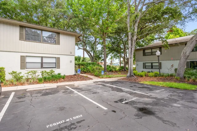 a view of a house with a yard and large tree