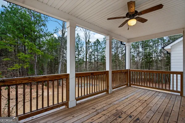 an empty room with a ceiling fan and windows