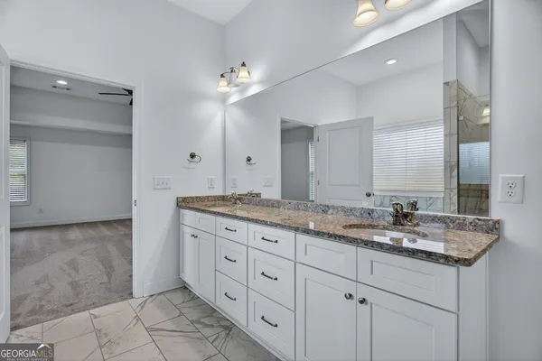 a bathroom with a granite countertop sink and a mirror