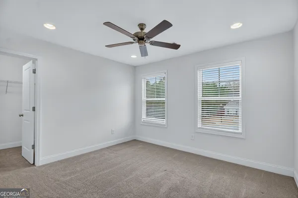 a view of a room with wooden floor and a ceiling fan