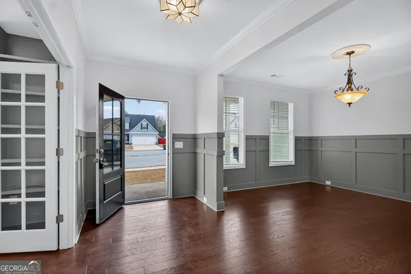 a view of an empty room with stairs and a chandelier