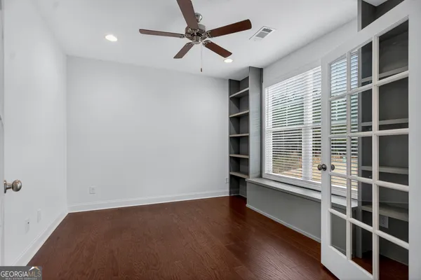 an empty room with wooden floor a fireplace and windows