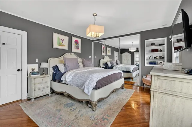a bedroom with a bed window and a flat screen tv