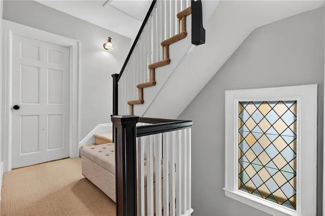 a view of staircase with railing and white walls