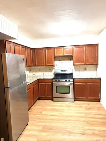 a kitchen with stainless steel appliances granite countertop a refrigerator a stove a sink and a microwave