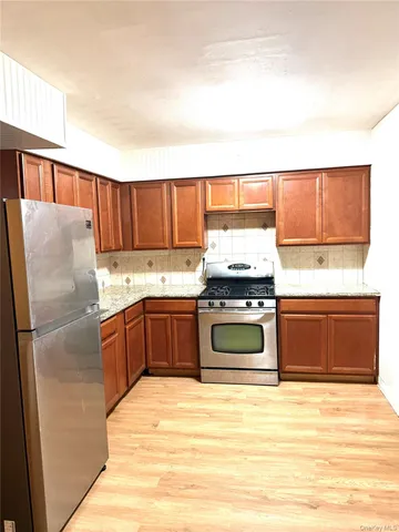 a kitchen with stainless steel appliances granite countertop a refrigerator a stove a sink and a microwave