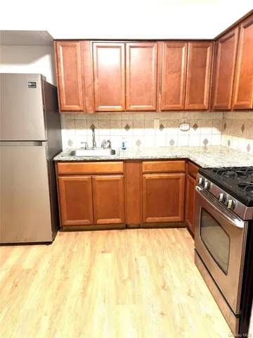 a kitchen with stainless steel appliances granite countertop a stove a sink and a refrigerator