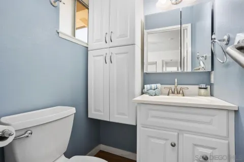 a bathroom with a granite countertop sink mirror vanity and toilet
