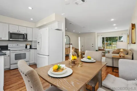 a kitchen with stainless steel appliances wooden floor dining table and chairs