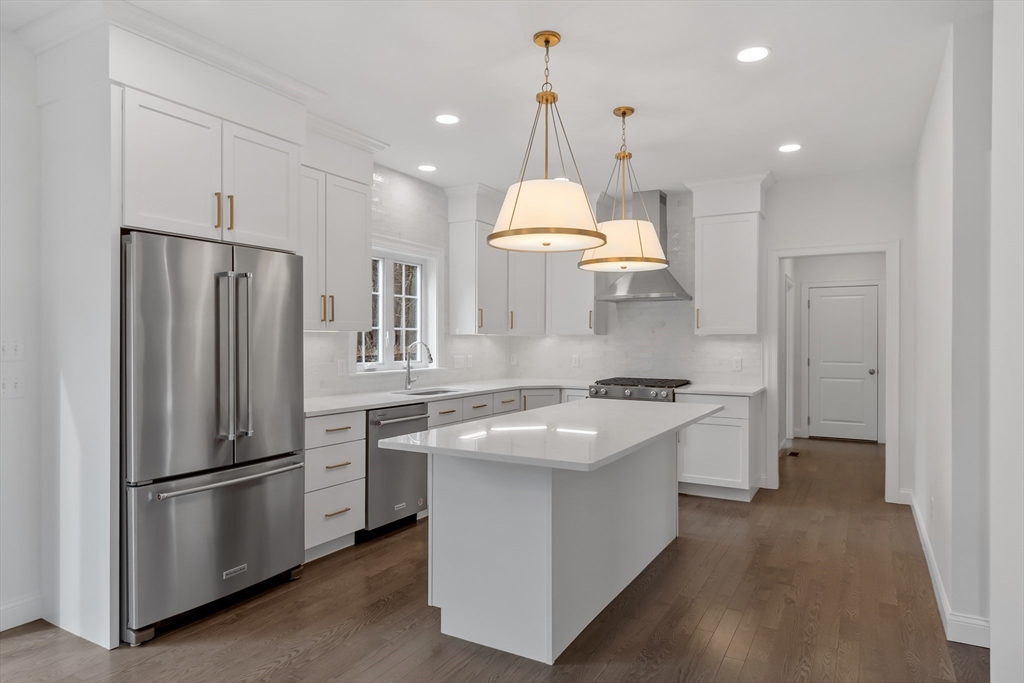 a kitchen with stainless steel appliances granite countertop a refrigerator a stove a sink and a refrigerator