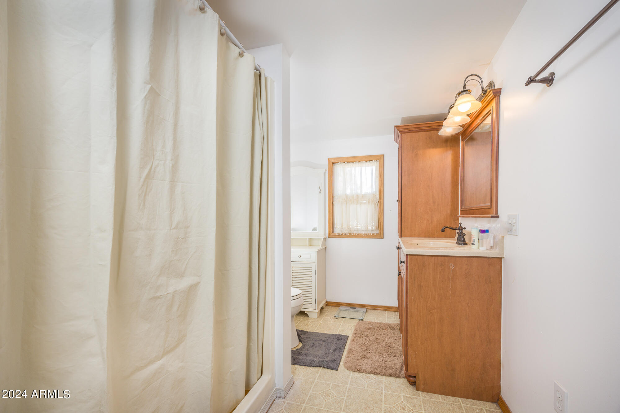 2980 West Williams Road Benson, AZ 85602 - Photo 11 of 32 a bathroom with a sink and mirror with bathtub