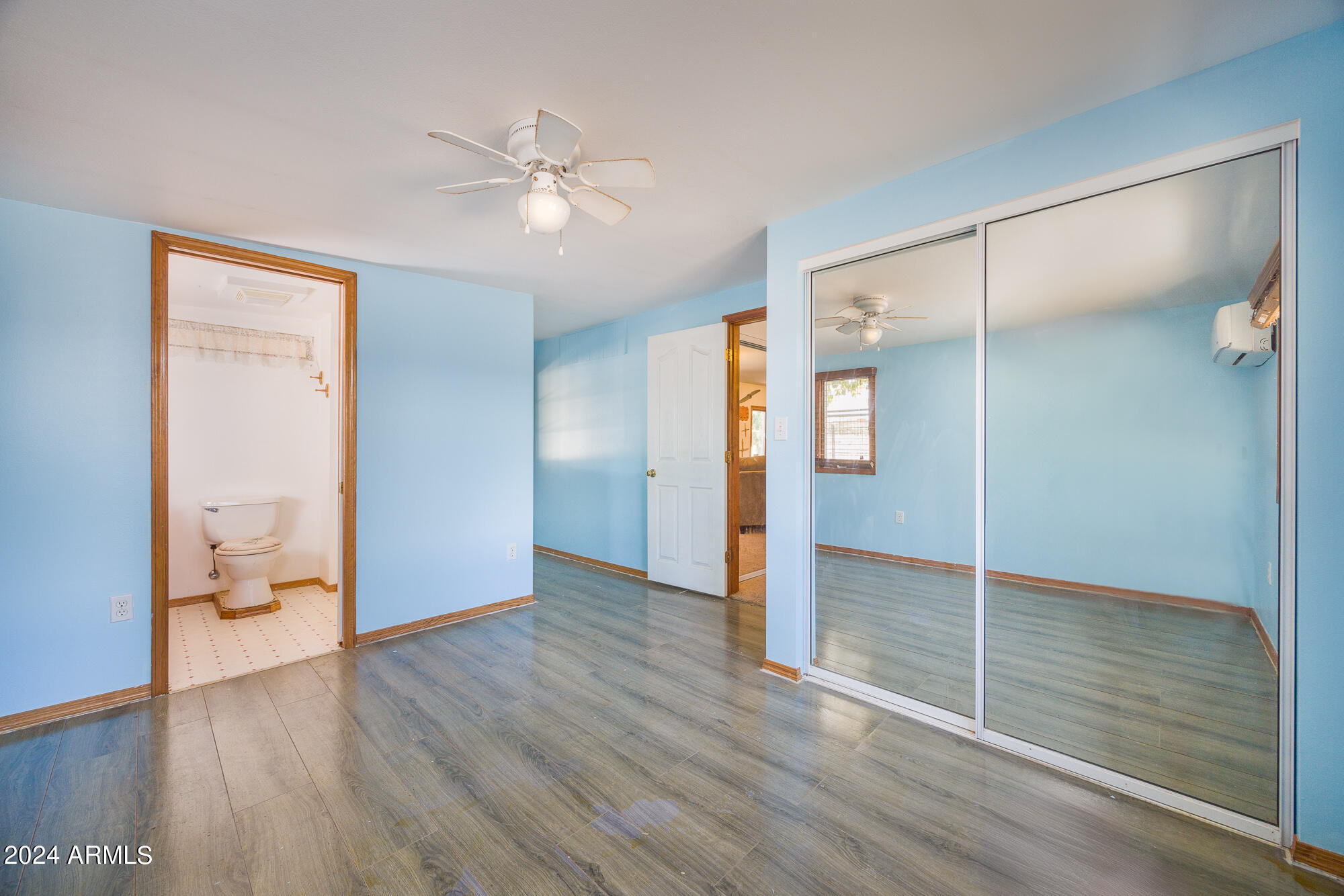 2980 West Williams Road Benson, AZ 85602 - Photo 16 of 32 a view of a livingroom with wooden floor and a ceiling fan