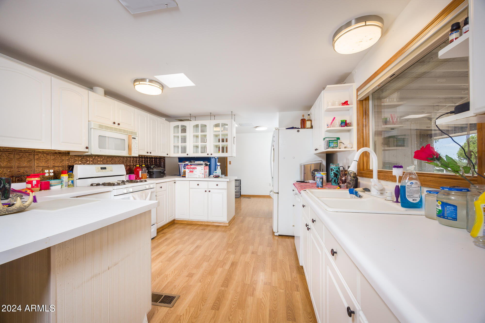 2980 West Williams Road Benson, AZ 85602 - Photo 7 of 32 a kitchen that has a lot of cabinets and wooden floor