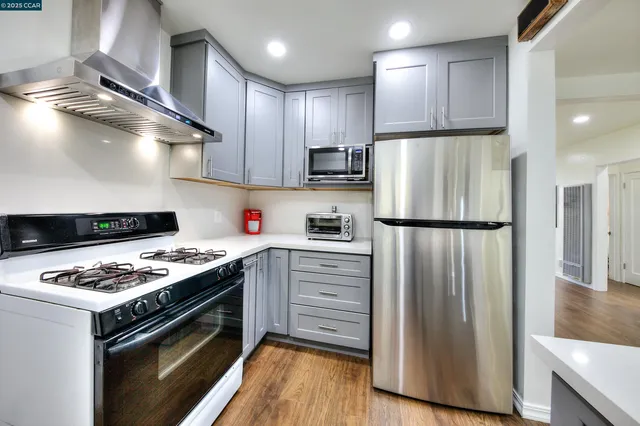 a kitchen with stainless steel appliances granite countertop a refrigerator stove sink and cabinets
