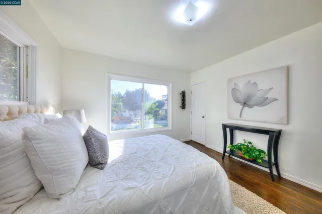 a bedroom with a bed a fireplace and a large window
