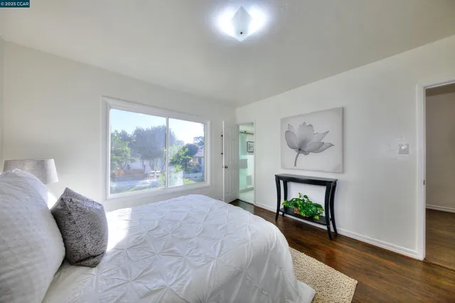 a bed sitting in a bedroom next to a window