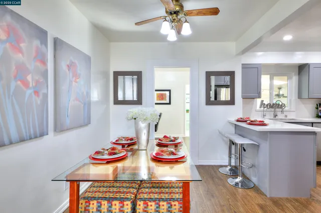 a view of a dining room with furniture and a chandelier fan