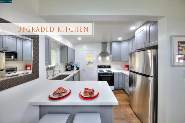 a kitchen with a refrigerator a stove a sink and cabinets