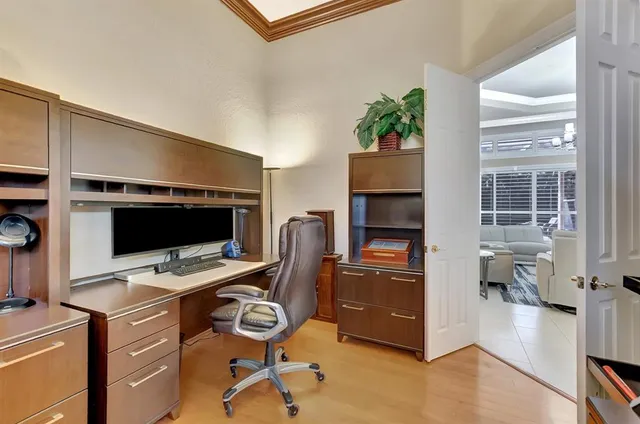 a view of a white house next to a yard with potted plants