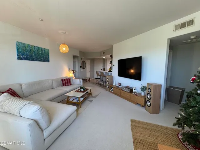 a view of a hallway with wooden floor and a vase with flowers