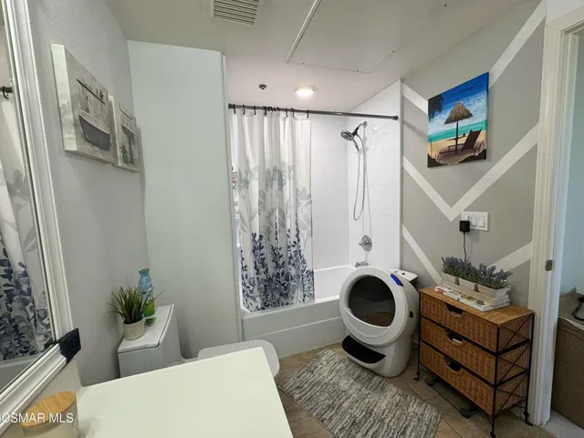 a spacious bathroom with a double vanity sink a toilet and a mirror