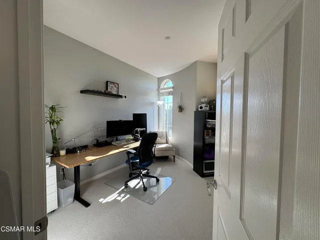 a view of a workspace with furniture and a window