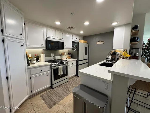a kitchen with white cabinets and white appliances