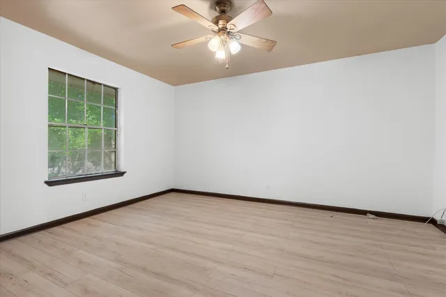 an empty room with fan and windows