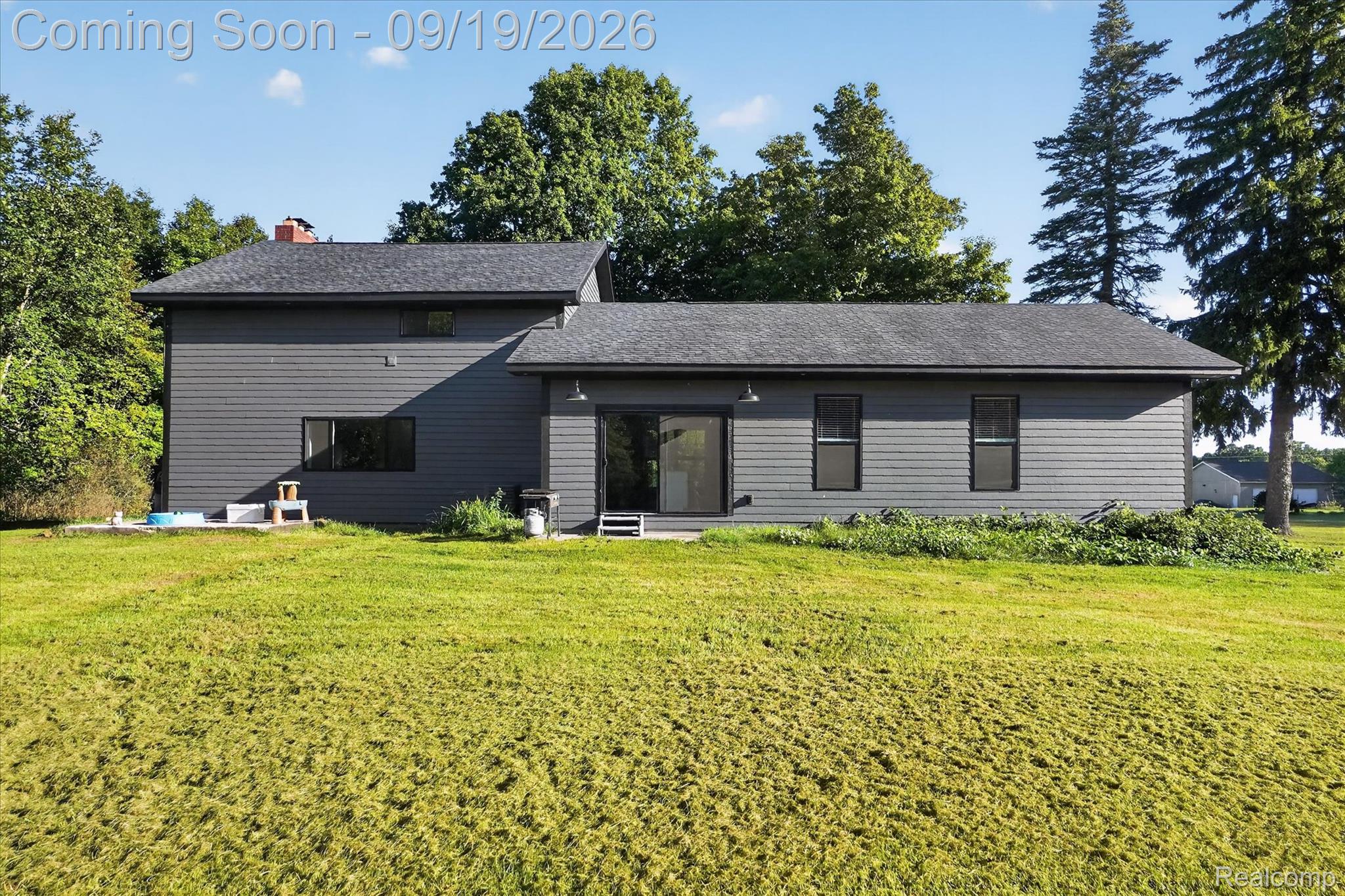 10215 West Mount Morris Road Flushing, MI 48433 - Photo 39 of 58 Dark gray horizontal siding, dark gray shingle roof, black-framed windows, and sliding glass door