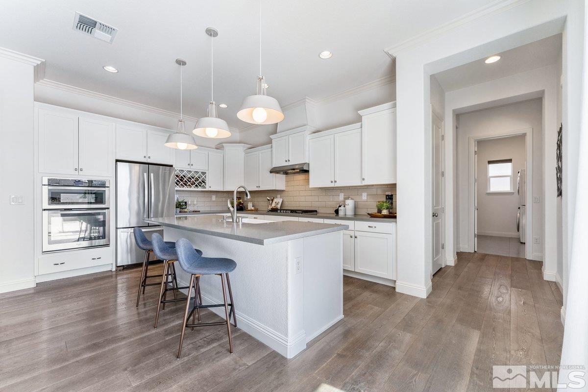 9815 Sea Bird Lane Reno, NV 89521 - Photo 11 of 40 a kitchen with kitchen island stainless steel appliances a dining table chairs sink and cabinets