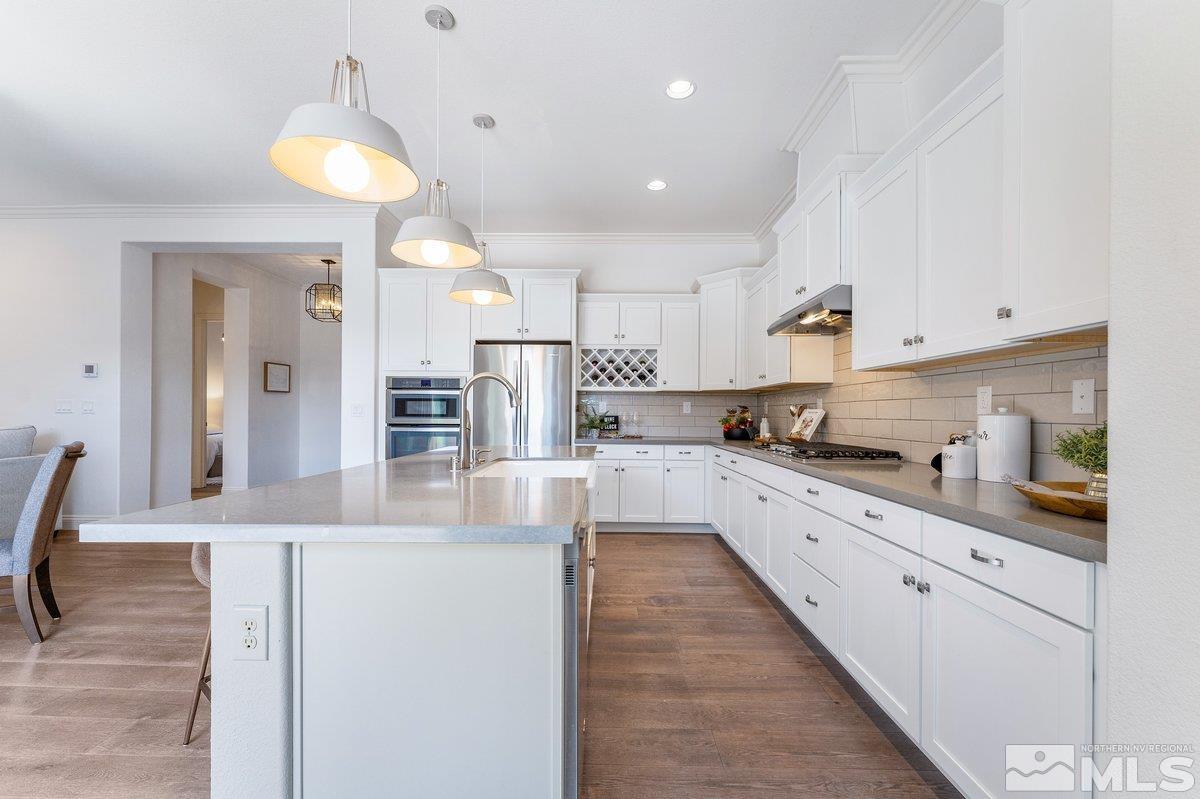 9815 Sea Bird Lane Reno, NV 89521 - Photo 9 of 40 a large kitchen with stainless steel appliances kitchen island granite countertop a refrigerator and a stove top oven